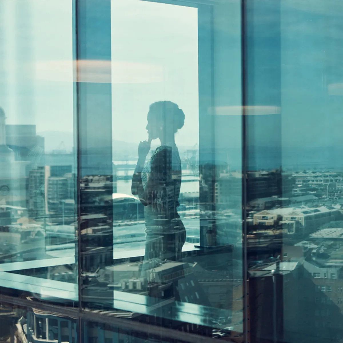person looking out the window into the city